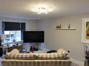 ein Wohnzimmer mit Sofa und Flachbildfernseher in der Unterkunft The Grange Cute Modern Stay in Gerrards Cross