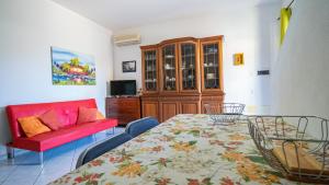 a living room with a table and a red couch at Domus Peppi in Villasimius