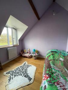 an attic room with a bed and a rug at Farm with view, horses and castles, plain nature in La Ferté-Saint-Cyr
