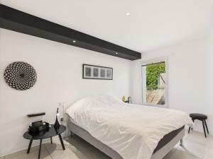 a white bedroom with a large bed and a window at Villa avec piscine - 500m de la plage de Rampillon in Longeville-sur-Mer +24 photos