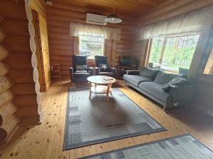 a living room with a couch and a table at Kalliorinteen Mökit Havupirtti in Töysä