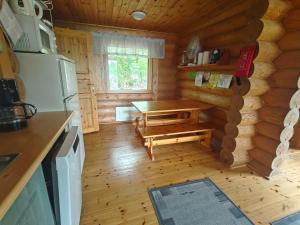 a kitchen with a table in a log cabin at Kalliorinteen Mökit Havupirtti in Töysä