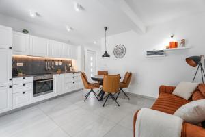 a kitchen with a couch and a table and chairs at Casa ol'Bol - Modern Apartment with Seaview and Private Large Backyard in Bol