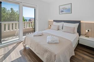a bedroom with a large bed with towels on it at Casa ol'Bol - Modern Apartment with Seaview and Private Large Backyard in Bol