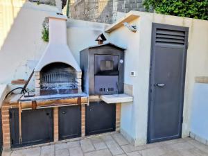 an outdoor grill with a pizza oven on the side of a building at Amoenus in Atessa