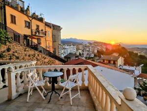 a balcony with chairs and a table and the sunset at Amoenus in Atessa