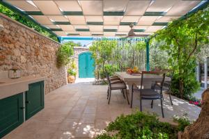 a patio with a table and chairs and a blue door at Casa ol'Bol - Modern Apartment with Seaview and Private Large Backyard in Bol