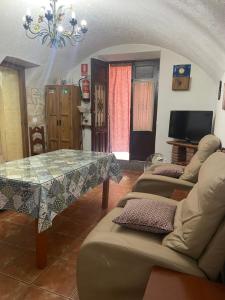 a living room with a table and couches at Cueva El Jaraiz in Guadix