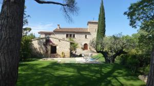 an exterior view of a stone house with trees at Cal Tomas in Castellet