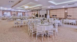 a banquet hall with white tables and chairs at Dafne Hotel in Ankara