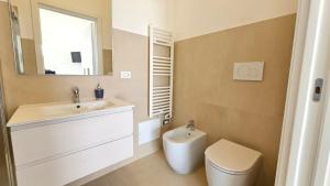 a bathroom with a sink and a toilet and a mirror at Villetta Maria in Porto Cesareo