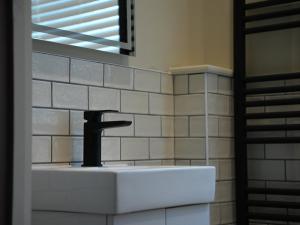a sink with a faucet in a bathroom at Spacious Cardiff Apartment for Large Groups! in Cardiff +39 photos