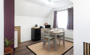 a room with a table and a chair and a kitchen at Lazy Acre Apartment - Heart of East Anglia in Hopton