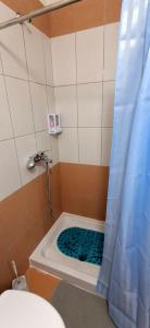 a bathroom with a shower with a blue shower curtain at Perla Blu Albania in Durrës +32 photos