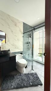 a bathroom with a toilet and a glass shower at De Flourishing Hill Pool Villa , Cha Am in Ban Nong Chaeng
