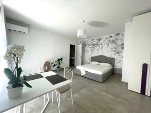 a bedroom with a bed and a table and a dining room at Villa Nina in Lagosanto