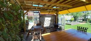 a patio with a table and chairs and an umbrella at Chambres d'hôtes Escale à Bouin in Bouin