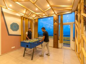 two men standing in front of a blue table at The Hosteller Kufri, Shimla in Kūfrī +20 photos