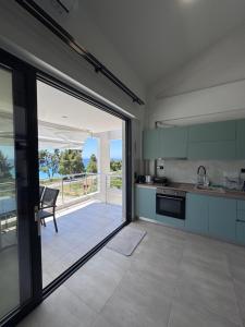 a kitchen with a sliding glass door leading to a patio at Casa de Lapel Mola Kaliva in Mola Kalyva