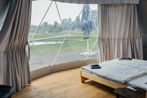 a bedroom with a large window with a bed in front of it at Glamping Prague Louka in Prague