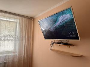 TV de pantalla plana colgada en una pared junto a una ventana en Modern Apartment - Calm Location - Boat in the Yard, en Chişinău