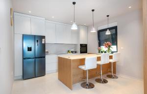 cocina con armarios blancos y nevera azul en Beautiful Home In Srima, en Srima