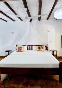 una camera da letto con un letto grande con soffitto di Simba House a Watamu