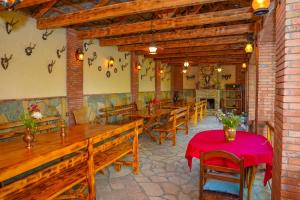 a restaurant with wooden benches and a red table at Merebashvili Estate in Kaspi