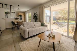 een woonkamer met een bank en een tafel bij Maison Landes in Mées