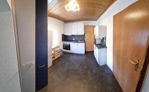 a kitchen with white appliances and a wooden ceiling at Ferienwohnung Zum Freihof in Schwarzenbach