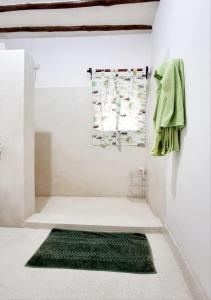 un bagno con un tappeto verde su una parete di Simba House a Watamu