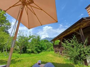 una persona è seduta sotto un ombrello di Bio Ferienwohnungen im Lieblingsort 1868 a Garmisch-Partenkirchen