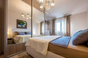 een slaapkamer met een spiegel en een bed bij Apartmani Tip-Top in Tivat