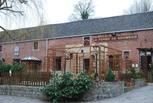 um edifício de tijolos vermelhos com um edifício em construção em Hotel Restaurant La Ferme de Grambais em Nivelles