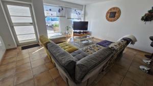 a large couch in a living room with a tv at Appartement Melou rez de chaussée in Gérardmer