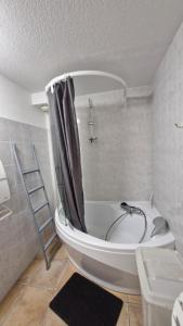 a bathroom with a bath tub and a sink at Appartement Melou rez de chaussée in Gérardmer +39 photos