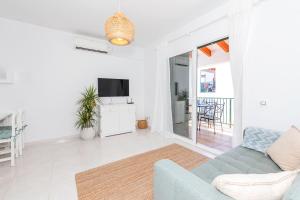 a living room with a couch and a tv at Apartamento Biniforcat 28 in Cala en Forcat