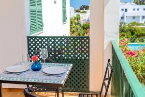 a table on the balcony of a house at Apartamento Biniforcat 28 in Cala en Forcat