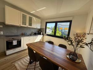 a kitchen with a wooden table with chairs and a window at WohlfühlWerk L4 in Mechernich