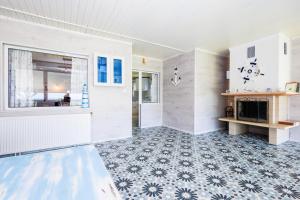 a living room with a fireplace and blue and white tiles at Вила Къщата с рибките in Sinemorets