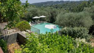 a swimming pool with chairs and umbrellas at Beautiful private villa with open views in Valbonne