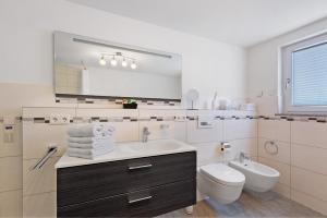 a bathroom with a sink and a toilet and a mirror at Reiselust in Stockach +22 photos