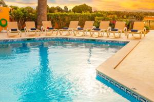 a pool with chaise lounge chairs and a swimming pool at Villa Palms by Algarve Vacation in Albufeira