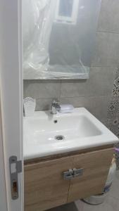 La salle de bains est pourvue d'un lavabo blanc et d'une douche. dans l'établissement Le paradis, à Martil