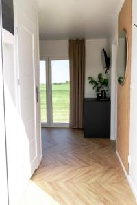 un pasillo con una puerta que conduce a una habitación con suelo de madera en Black Water Links Village, 