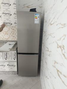 - un réfrigérateur blanc installé dans une pièce à côté d'un mur dans l'établissement Le paradis, à Martil