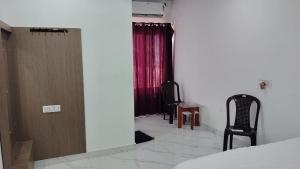 ハルドワニにあるHotel Buransh Innのベッドと赤いカーテンが備わる部屋