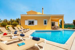 a villa with a swimming pool and lounge chairs at Villa Palms by Algarve Vacation in Albufeira
