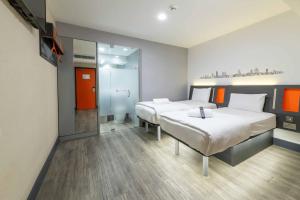 a hotel room with two beds and a mirror at easyHotel Leeds in Leeds