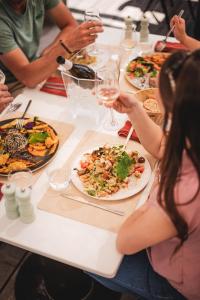 a group of people sitting around a table eating food at Le Phare in Les Portes